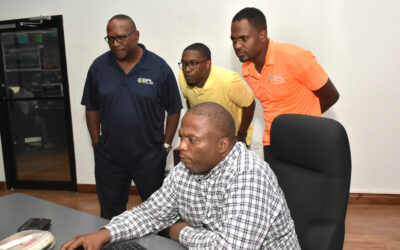 Valen Wilson (sitting), Assistant Control Engineer – Generation, sharing his screen with an attentive team visiting from Bahamas Power and Light (BPL) – (l-r) Sterling Moss, Director of Field Operations; Mathew Beckles, Assistant System Controller and Shevon Whilby, Protection and Metering Manager. The BPL team visited and observed one of JPS’ recent Hurricane Simulations