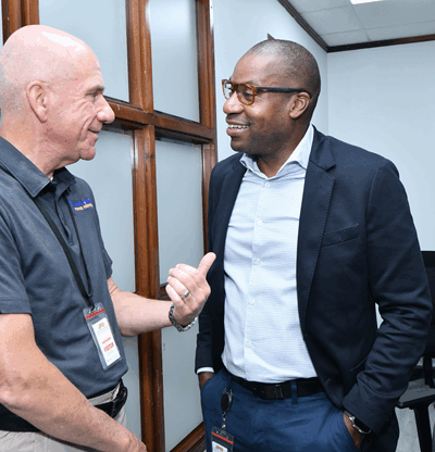 (L-R) Alan Brandshaw, Vice President of Utility Relations at Holland Power Services and Hugh Grant, President and CEO of JPS, share a light-hearted chat on a session break. Holland Power Services is one of the contracting firms on standby to support JPS in its restoration efforts, should the country be severely impacted by a hurricane.